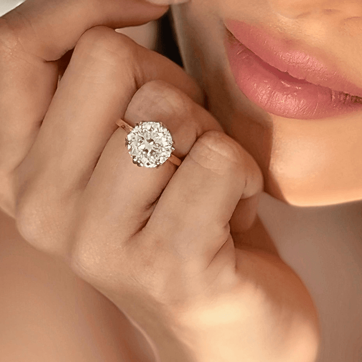 Lifestyle image of Portuguese Cut 4 Carat Big Rock Solitaire Ring worn on hand against soft-focus background