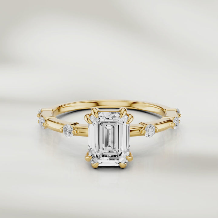 360-degree view of the Solstice Radiant Band in 18K yellow gold, featuring an emerald-cut diamond center and evenly spaced round diamond accents, shown in full rotation to highlight every detail