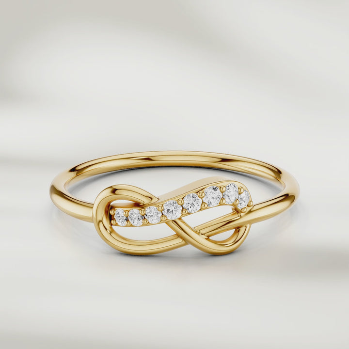 360-degree video of infinity knot diamond ring in gold with pavé-set accents and slim polished band