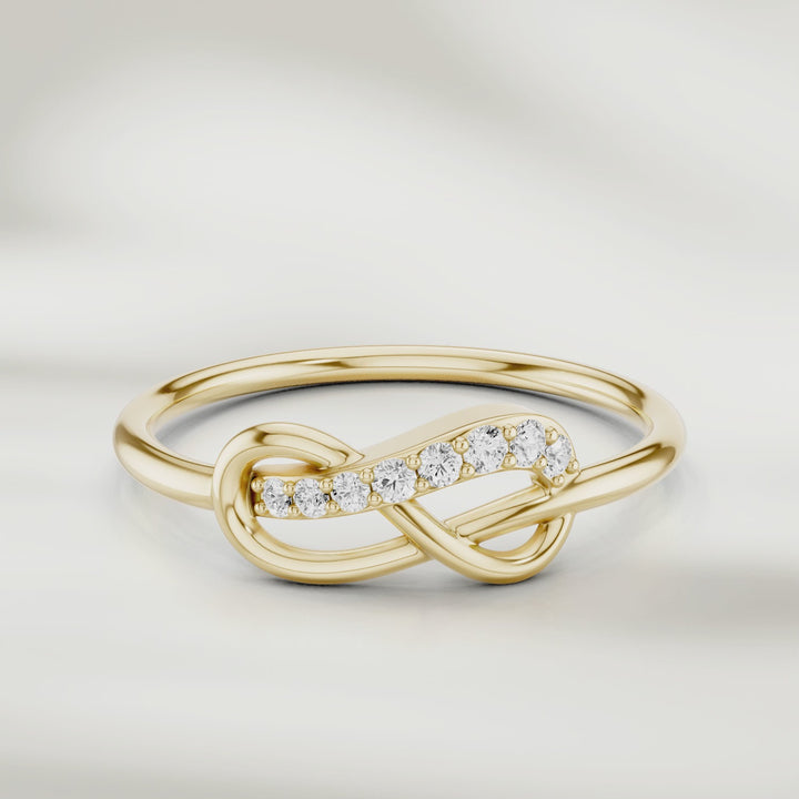360-degree video of infinity knot diamond ring in gold with pavé-set accents and slim polished band