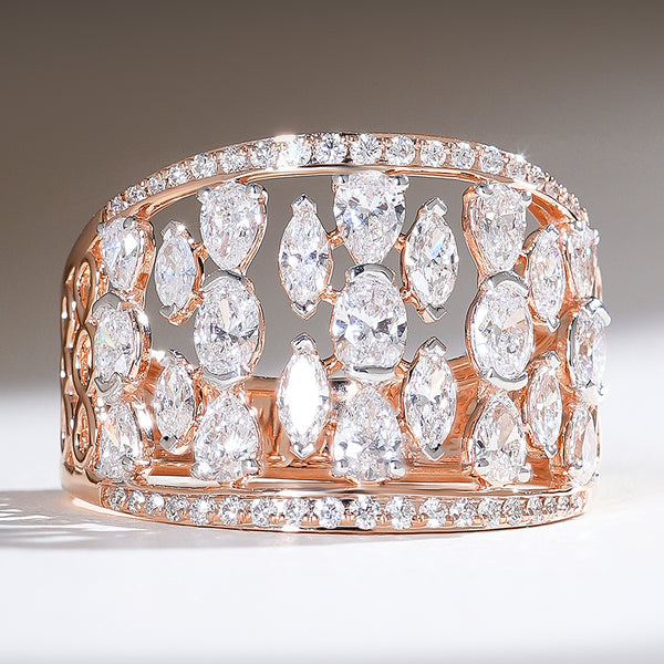 Front view of the Raindrop Cocktail Ring in rose gold, featuring a wide band encrusted with marquise and pear-shaped diamonds, framed by two rows of pavé diamonds