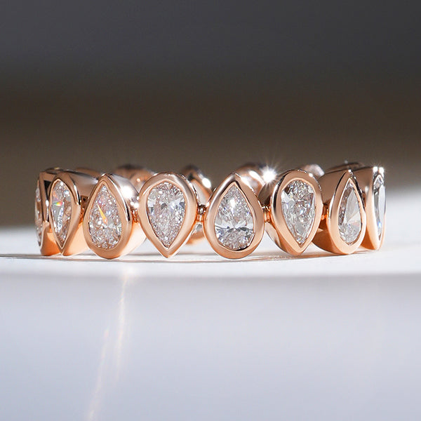 Front view of a 1.7 Ct reverse pear eternity band in rose gold with bezel-set pear-shaped diamonds