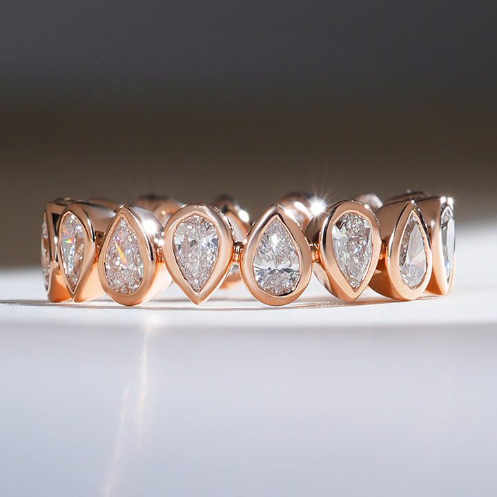 Front view of a 1.7 Ct reverse pear eternity band in rose gold with bezel-set pear-shaped diamonds