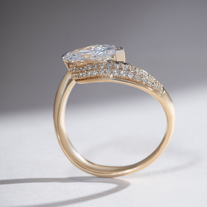 Side profile of 18K yellow gold ring featuring a 1-carat marquise diamond with pavé-set accents along the curved band.