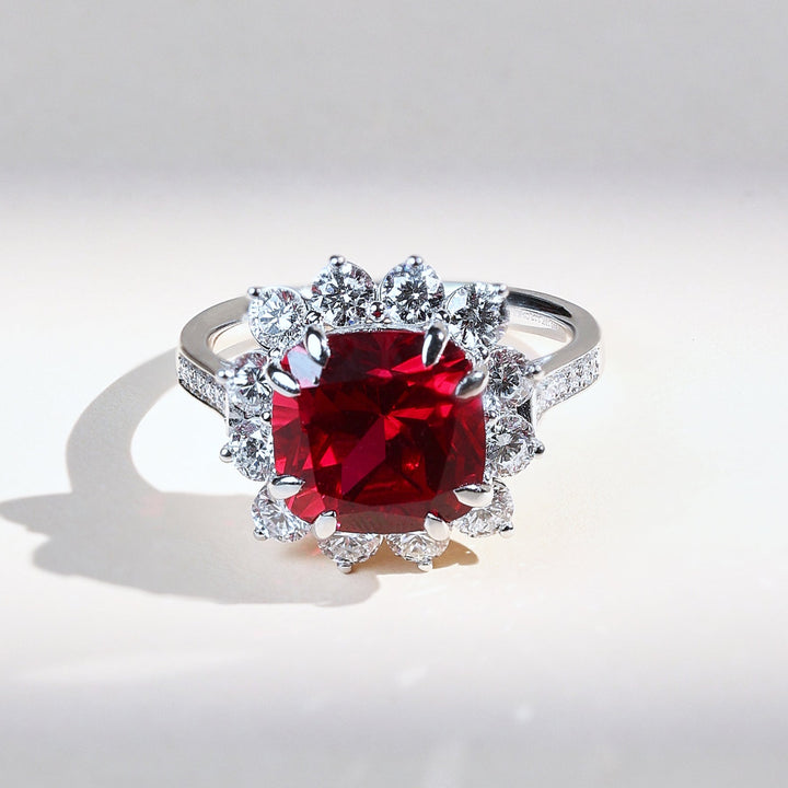 Front view of Ruby Embrace cocktail ring with ruby centerpiece and diamond-studded halo