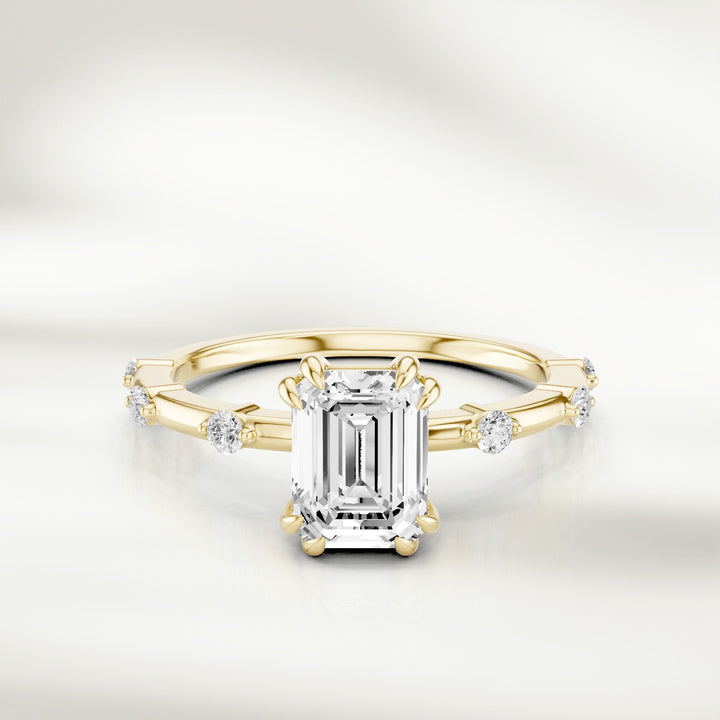 18K champagne gold solitaire ring with an emerald-cut diamond centerpiece and evenly spaced round diamond accents along the band.