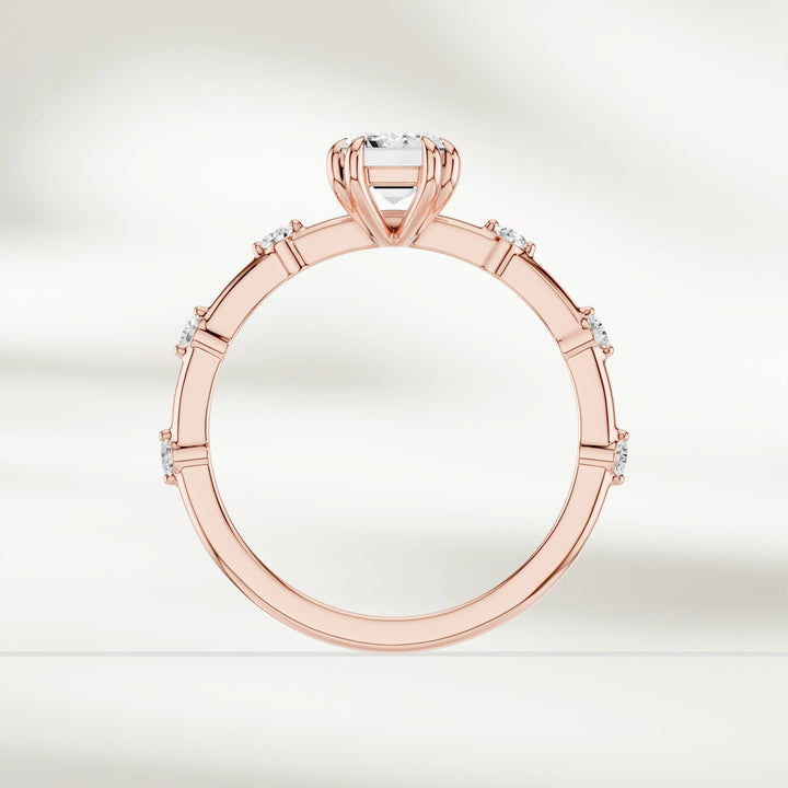 Top-down view of 18K yellow gold solitaire ring with emerald-cut diamond and round brilliant accents.