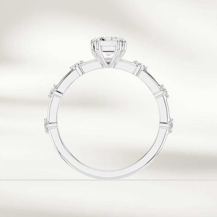 Top-down view of 18K white gold solitaire ring with emerald-cut diamond and round brilliant accents.