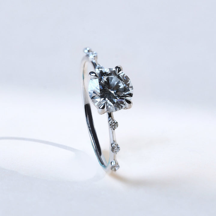 Side view showing raised round solitaire and accent diamonds along band.