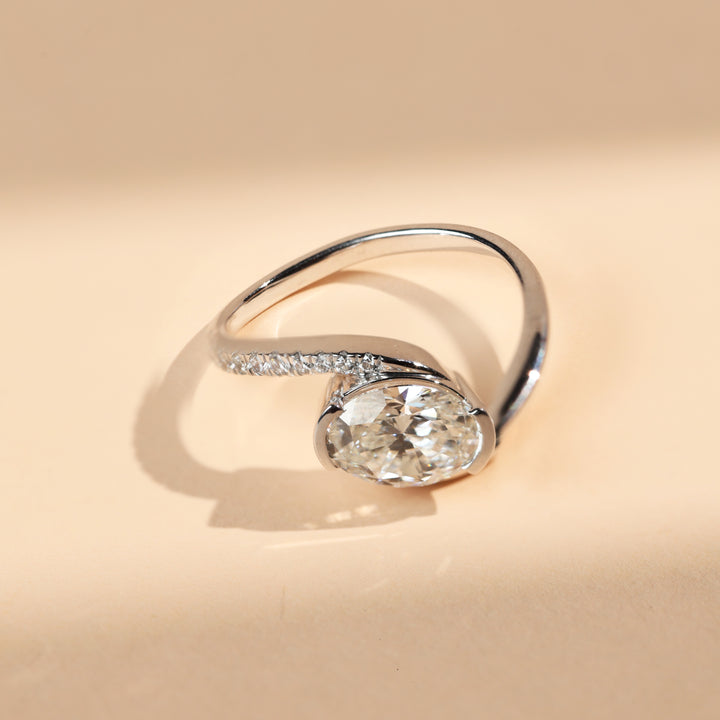 Angled view of oval solitaire diamond ring with sleek twist band