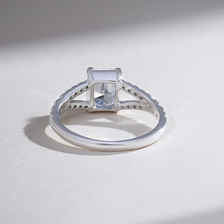 Back view of radiant solitaire ring with split shank pave design and open gallery.