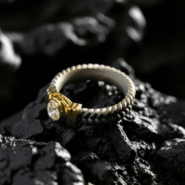 Stonecrest Titanium Ring placed on dark rock, showcasing diamond and rope-textured titanium shank.