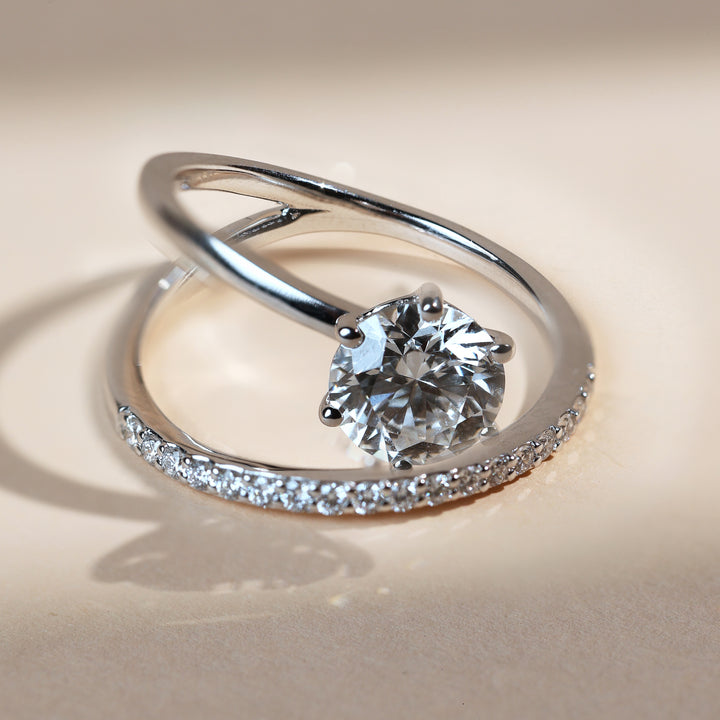 Angled view showing the crossover twist and a row of pavé stones along one arm.