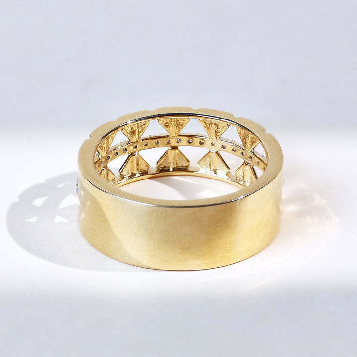 Back of ring displaying smooth gold band with inner shield motifs.