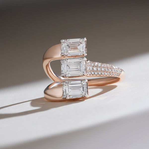 Close-up front view of The Trinity Cocktail Ring with three emerald-cut diamonds in rose gold.