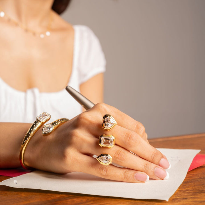 Model wearing the Three Lovers Cocktail Ring with matching diamond cuff bracelet, holding a pen.