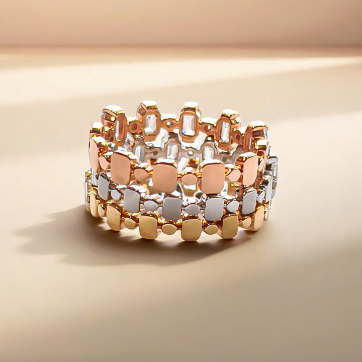 Back view of stacked white, yellow, and rose gold diamond rings