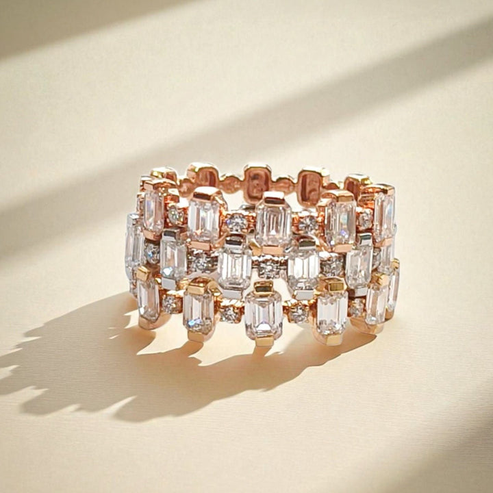 Trio of stackable rings in white, yellow, and rose gold with emerald-cut diamonds