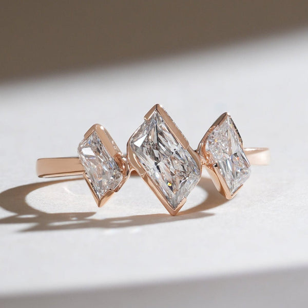 Front view of the Triad Spark 1 Ct Radiant Three Stone Cocktail Ring in rose gold with three radiant-cut diamonds in bezel settings.