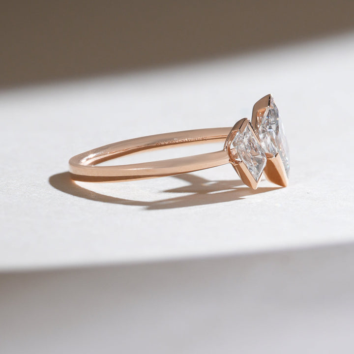 Side profile of the Triad Spark ring showing slim rose gold band and elevated diamond settings.