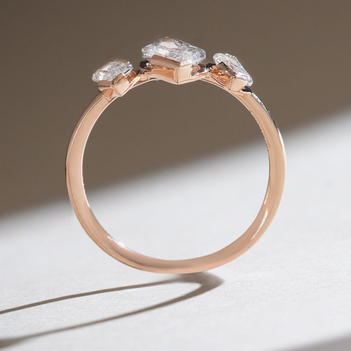 Overhead view of the Triad Spark ring with symmetrical radiant-cut diamond arrangement on a polished rose gold band.