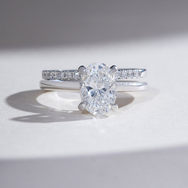 Oval-cut diamond engagement ring in white gold with pavé-set diamond band
