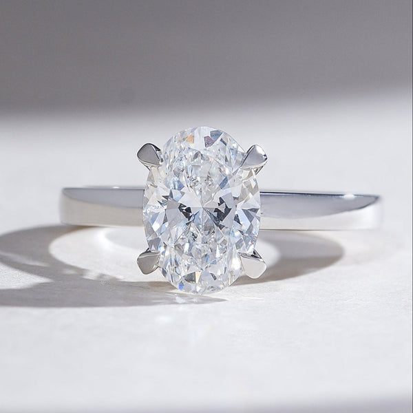 2 carat oval-cut diamond solitaire ring in white gold with claw prong setting and hidden halo accent diamonds