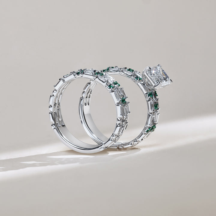 Side view of Twin Gleam white gold stackable ring set with emerald-cut diamond and green stones
