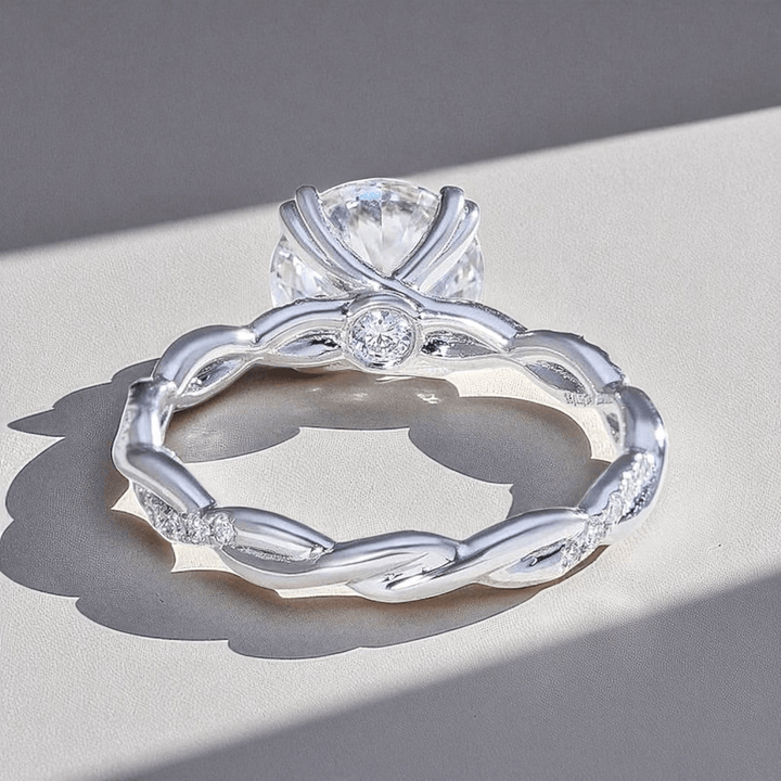 Back view highlighting the intertwined band design and heart-prong detailing