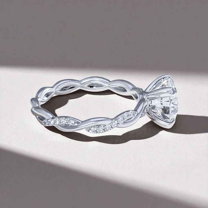 Side view showing the twisted diamond-studded band and the elevated round solitaire setting.