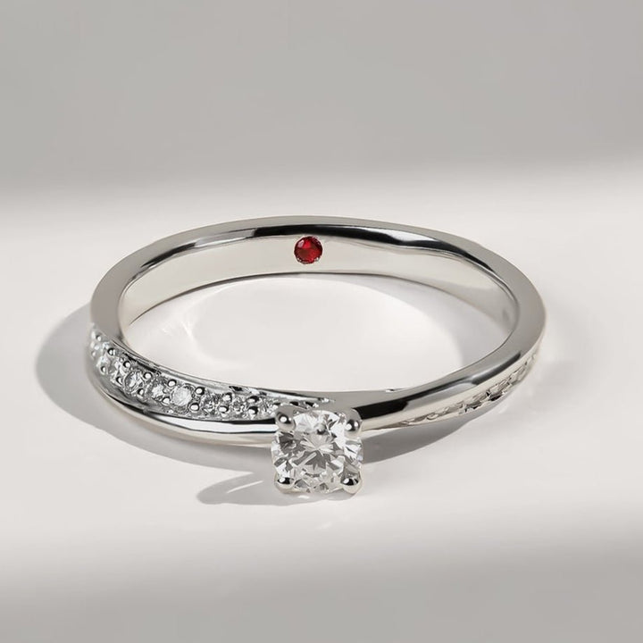 Angled shot of Vow To Love Promise Ring showing solitaire and pavé-set diamonds on sleek white gold band.